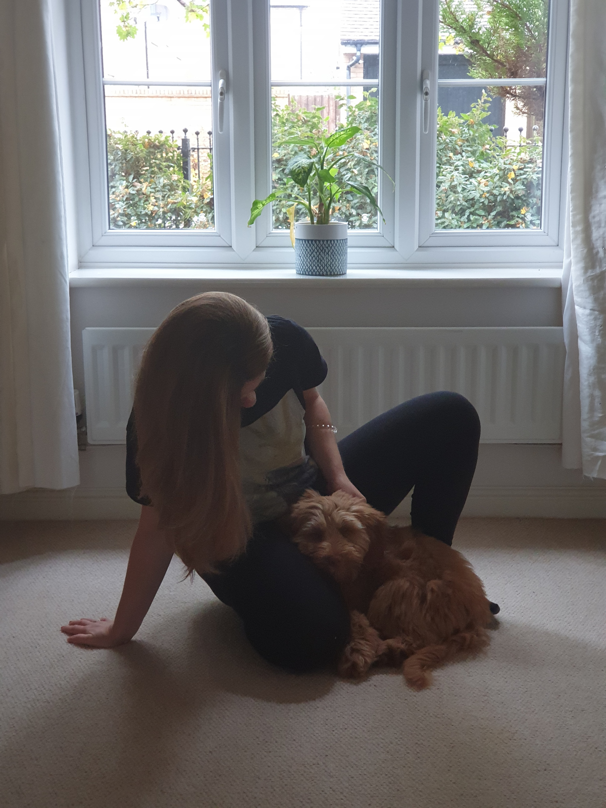 Kamila, the Ruff Pooch's primary dog trainer, and her dog Alf, who is resting comfortably on her lap.